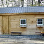 Post and Beam 12x20 Garage with gray metal roof, clapboard siding, hinged windows and flower boxes