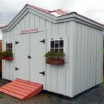 An upgraded tool shed with autumn red roof, flower boxes and paint
