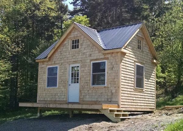 12x16 Cross Gable with matte black roof, cedar shingle siding, insulated windows and roof flashing for a wood stove.