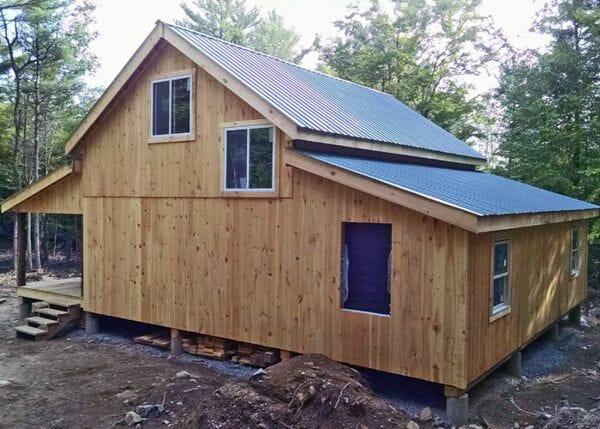20x30 Vermont Cabin modified with two overhangs. One of the overhangs is being enclosed to create an additional room.