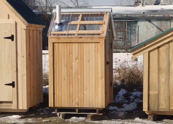 This functional outhouse was modified to have a clearpoly roof and tongue and groove siding