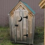 4x4 Outhouse Shed includes green metal roof, pine board and batten siding and a single door with moon cutout