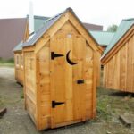 This functional outhouse was updated with shiplap pine siding and a gray metal roof