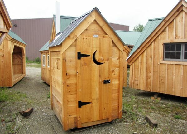 This functional outhouse was updated with shiplap pine siding and a gray metal roof