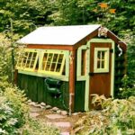6x8 Greenhouse that has been painted green, yellow and brown with a custom door
