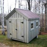 8x10 Gable with brown roof and gray painted sides. Includes a double door and two hinged windows