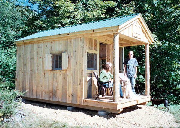 8x16 Bunkhouse with extra windows and screens. A couple with a dog are sitting on the porch