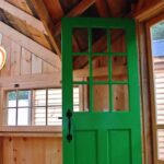 The roundel and green door in this cabin add pops of color