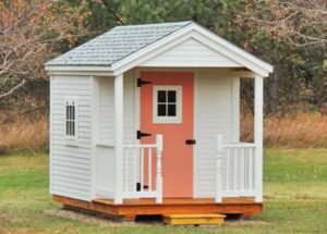 8x12 Nook post and beam cabin with clapboard siding, asphalt shingle roof and porch railing.