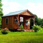 10x16 Pond House includes a green metal roof, pine board and batten siding and insulated windows and doors. This post and beam cabin includes a porch