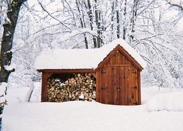 A dual-purpose storage shed provides storage for firewood and gardening tools. 