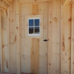 2-8 JCS Built 2" thick Pine Single Door with 16"x21" Fixed Window on 12x20 Gibraltar. Exterior view. Black Turn Latch.