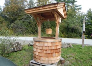 Wooden cedar wishing well with bucket