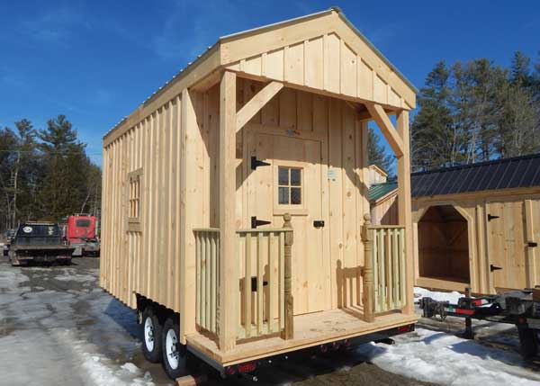 Wooden tiny house on wheels with a porch