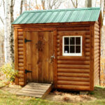 Small backyard shed with log cabin siding.