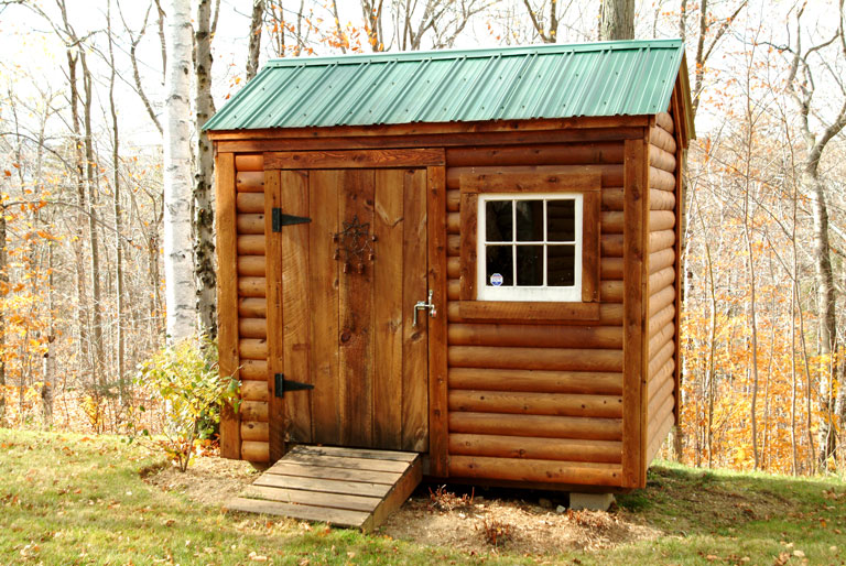 Small backyard shed with log cabin siding.