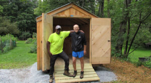 A happy customer posing with his shed and delivery driver