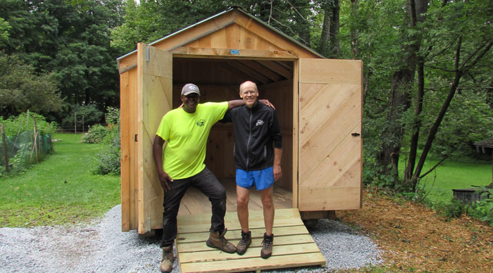 A happy customer posing with his shed and delivery driver