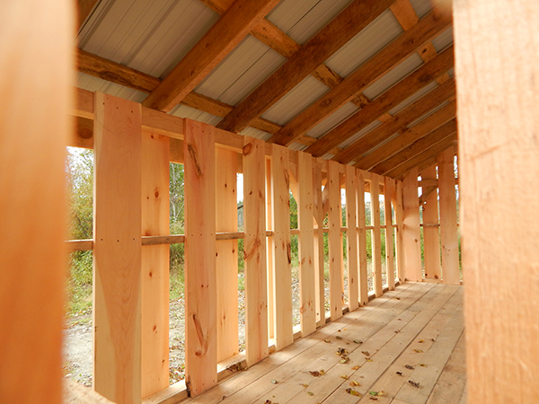 A peek at the interior of a 10x20 Woodbin with alternating pine board siding and a hemlock floor system.