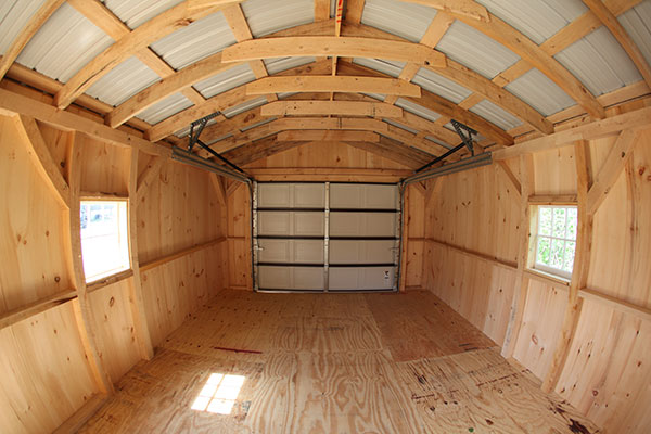 Garage interior with overhead door and wooden floor system.