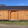 large storage shed with three slidiing doors.