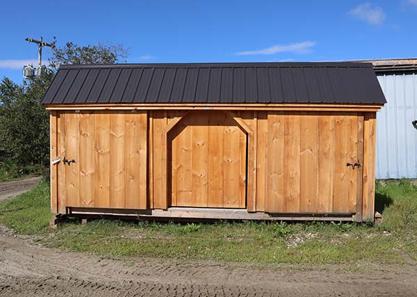 large storage shed with three slidiing doors.