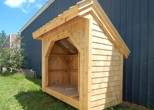 The 4x8 Woodbin holds one cord of wood. This one was custom built with cedar shingle siding.