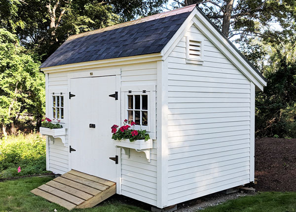 8x12 Church Street - white storage shed with clapboard siding and flower boxes