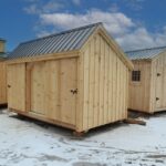New England style storage shed with three openings.