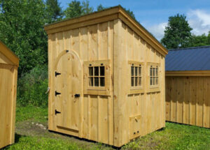 Extra barn sash windows, a pine arched barn door and coop door make this simple shed roof building unique.