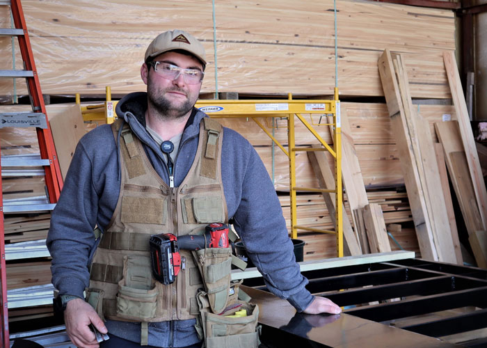 Jamaica Cottage Shop Employee Stands Next To Tiny House Trailer