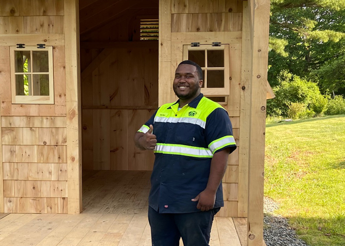 Jamaica Cottage Shop Employee Poses with a Garden Shed