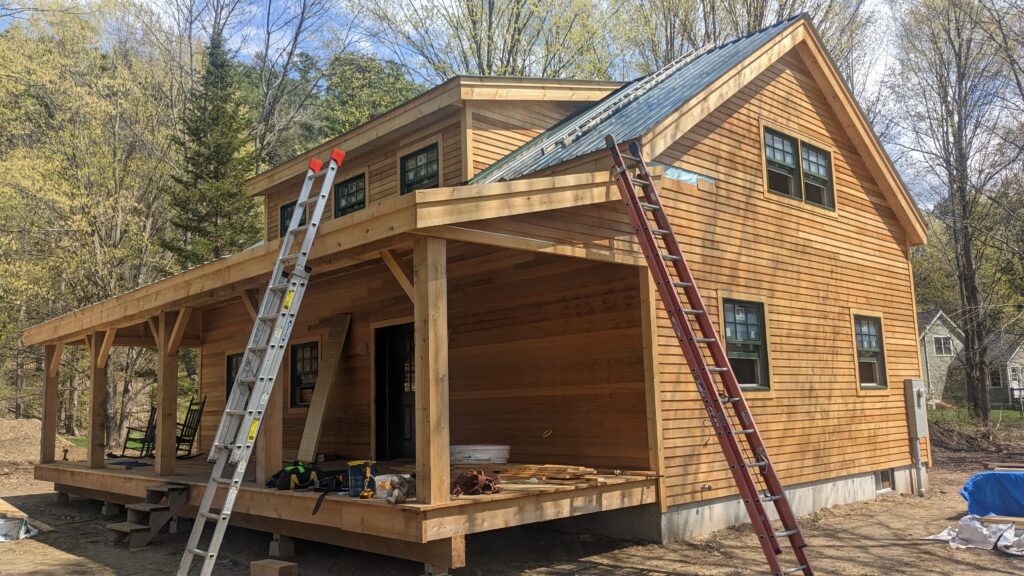 Vermont Cabin at the end stages of the building process with brown clapboard siding.